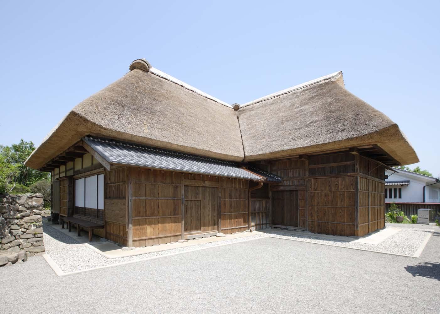 青空の下、多良木町大字多良木字中仁原に建つ木造の太田家住宅の写真。