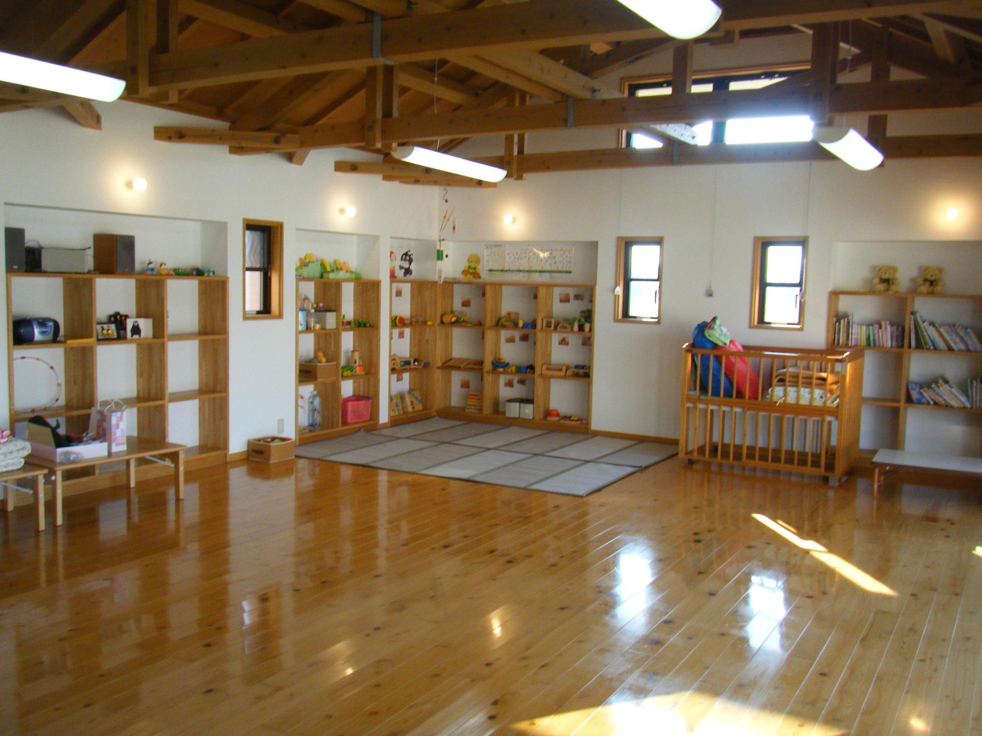 光台寺保育園子育て支援センター内部の写真。木製の棚にはおもちゃや絵本がある。